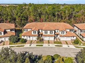 A residential area with multiple houses, each with a red-tiled roof and white walls, surrounded by greenery. - 12 Mi to Disney! Resort Pool, Gym (Davenport)