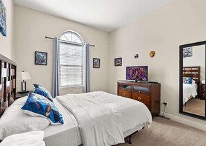 A bedroom with a bed, dresser, mirror, and wall art. - 12 Mi to Disney! Resort Pool, Gym (Davenport)