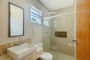A bathroom with a sink, toilet, and glass-enclosed shower. - Beautiful Apartment 130m From the Beach Mut0054 (Porto Seguro)