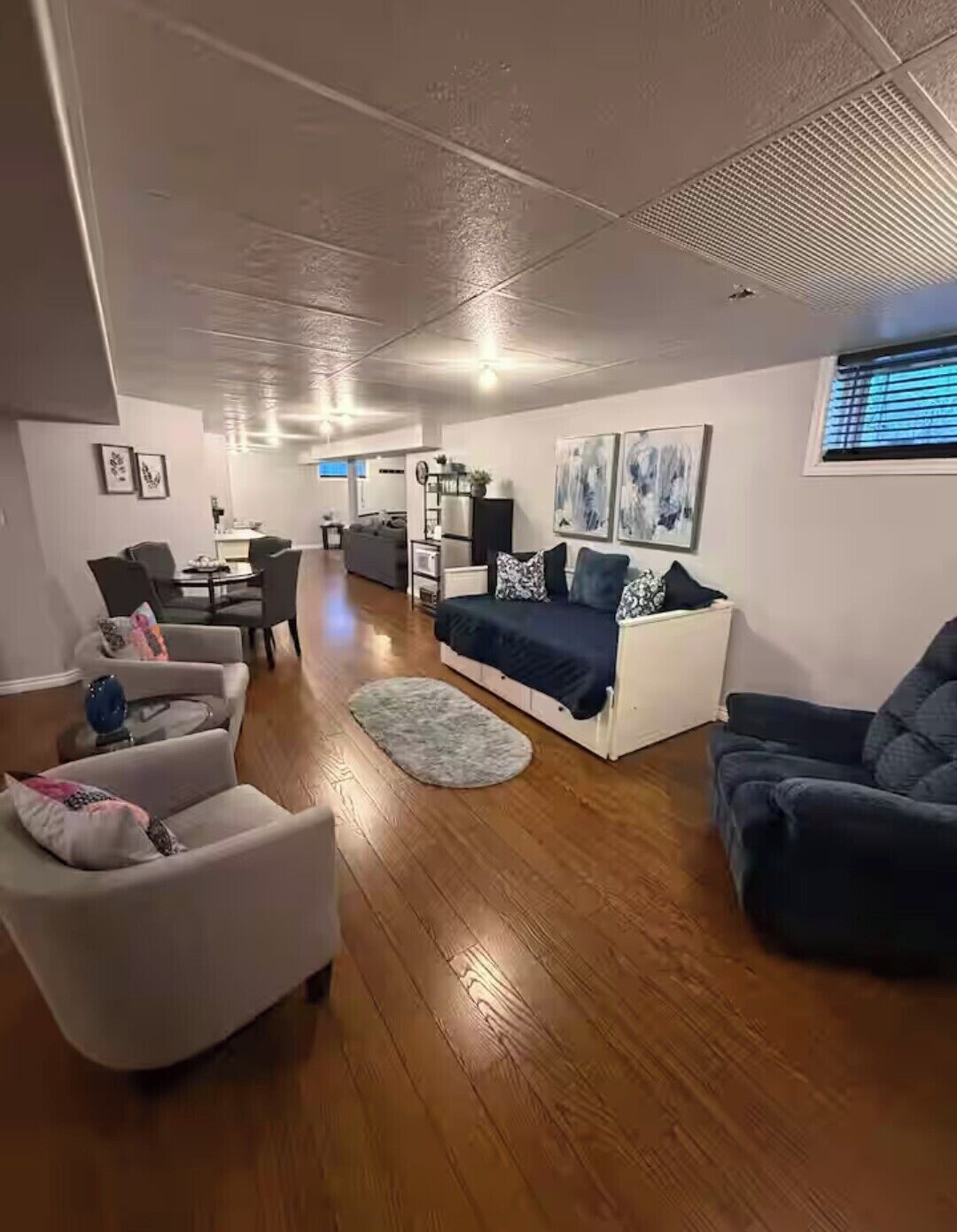 A spacious living area with a sofa, armchairs, and a dining table.