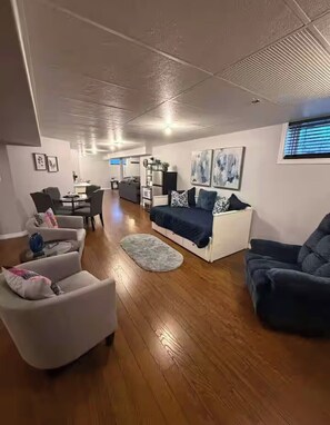 A spacious living area with a sofa, armchairs, and a dining table. - 2 BD Apartment-Sleeps 5
Near Stonefields Estate & Mississippi River, Heated Pool (Carleton Place)