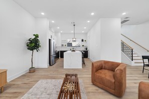 A modern living space with a kitchen, a dining area, and a staircase.