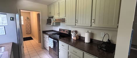 A kitchen with a refrigerator, stove, microwave, and cabinets.