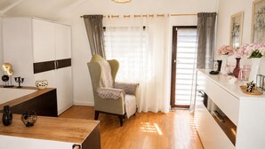 A modern kitchen with a wooden countertop, a chair, and a dining table. - Mrzezyno Holiday Home for 5 People (Trzebiatow)