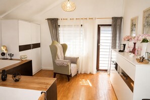 A modern kitchen with a wooden countertop, a chair, and a dining table. - Mrzezyno Holiday Home for 5 People (Trzebiatow)