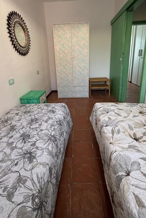 A room with two beds, a mirror, a wardrobe, and a bench. - Cozy vacation home 250 meters from the beach, with reserved parking and free Wi-Fi (Cannigione)
