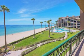 Ein Resort mit Strand, Poolbereich und einem Hotelgebäude.
