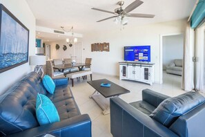Ein Wohnzimmer mit einer Couch, einem Couchtisch und einem Fernseher.