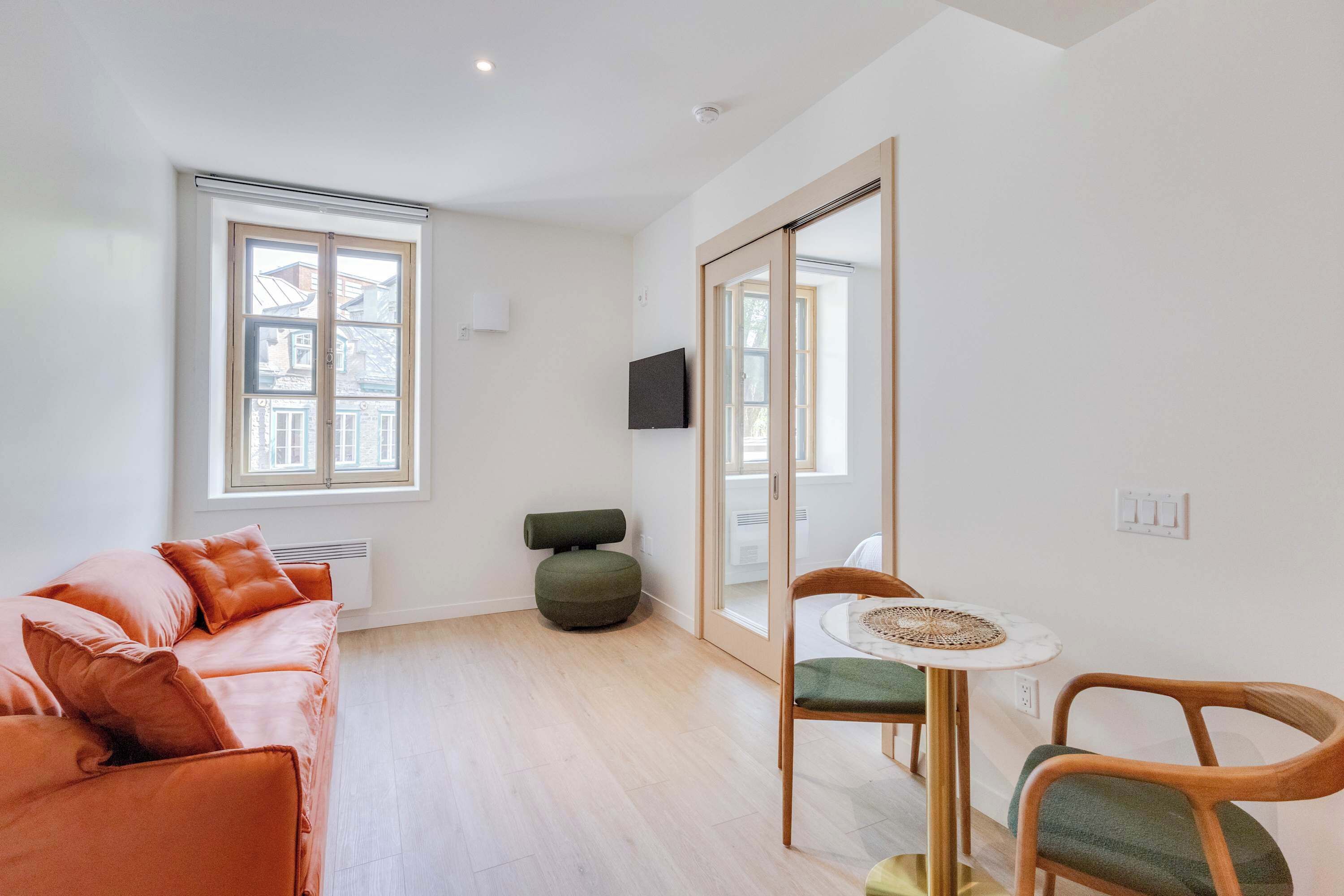 A modern living room with a sofa, a small round table, and a chair.