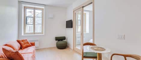 A modern living room with a sofa, a small round table, and a chair.
