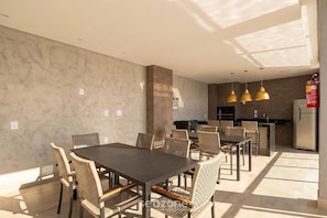 A modern kitchen with a built-in stove, a refrigerator, and pendant lights. - Apt. in Condo. w/ Pool & City View Grla1202 (Anapolis)