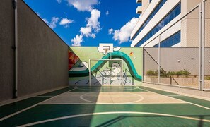 An outdoor basketball court with a mural, surrounded by buildings. - Apt. in Condo. w/ Pool & City View Grla1202 (Anapolis)