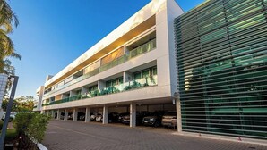 A multi-story building with a covered parking area. - Apt. w/ Balcony in Condo. w/ Pool Lvt0031 (Brasília)