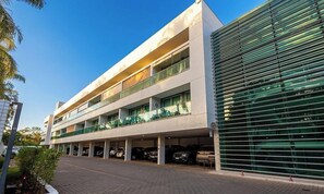 A multi-story building with a covered parking area. - Apt. w/ Balcony in Condo. w/ Pool Lvt0031 (Brasília)