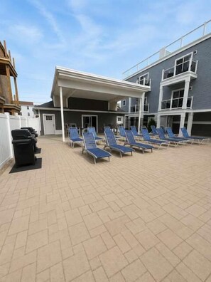 A covered outdoor area with multiple sun loungers arranged in rows. - Kays Oasis 13 Wildwood (Wildwood)
