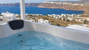 A hot tub with a view of a coastal town and cliffs. - Santo Caves Santorini Suite With Private Hot Tub (Santorini)