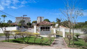 Propiedad amurallada con un camino de entrada pavimentado que conduce a un edificio con techo de tejas.