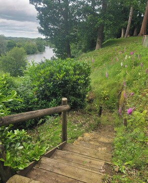A wooden staircase leading to a grassy area with a river in the background. - Private riverside escape with spectacular views, Staithe Cottage, Bramerton. (Bramerton)