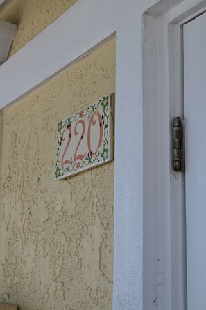 A house number '220' on a textured wall. - Stylish Deluxe Gulf View studio, with jacuzzi tub (Bradenton Beach)