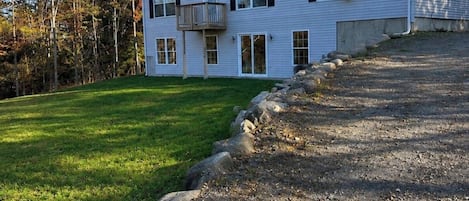A two-story house with a front porch, a visible garage, and a driveway leading to the house.