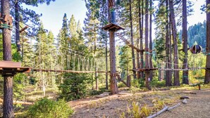 An outdoor ropes course in a forested area with wooden platforms and suspended ropes. - Condo at Granlibakken Tahoe Resort - Ski-In - Ski-Out with Pool, Spa & Minutes from Lake Tahoe (Tahoe City)