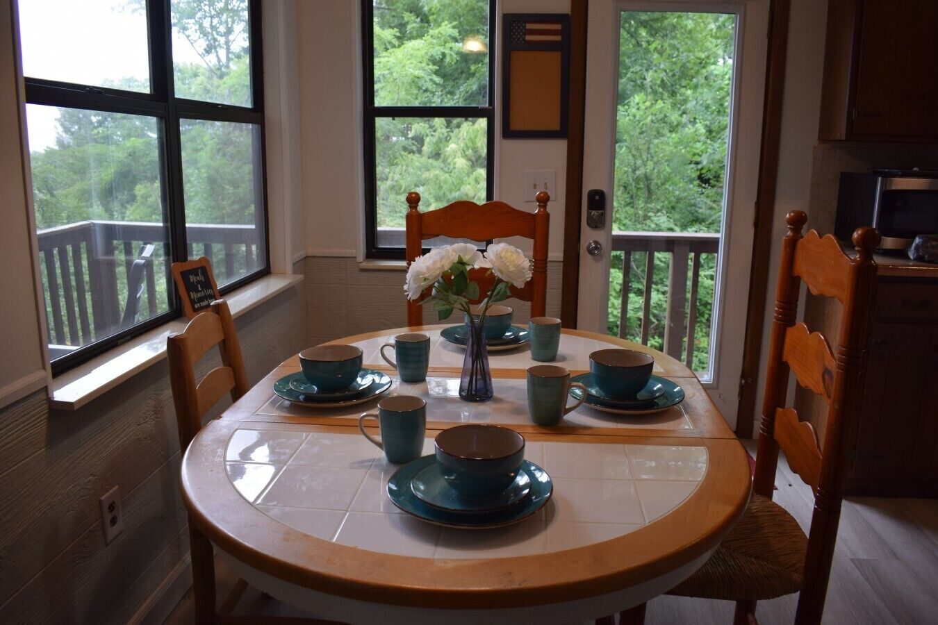 A dining area with a round table, chairs, and a vase with flowers.