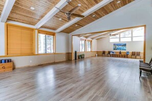 A spacious room with wooden floors, large windows, and ceiling fans. - Cozy Studio at Granlibakken Tahoe Resort - Ski-In - Ski-Out with Pool, Spa & Minutes from Lake Tahoe (Tahoe City)