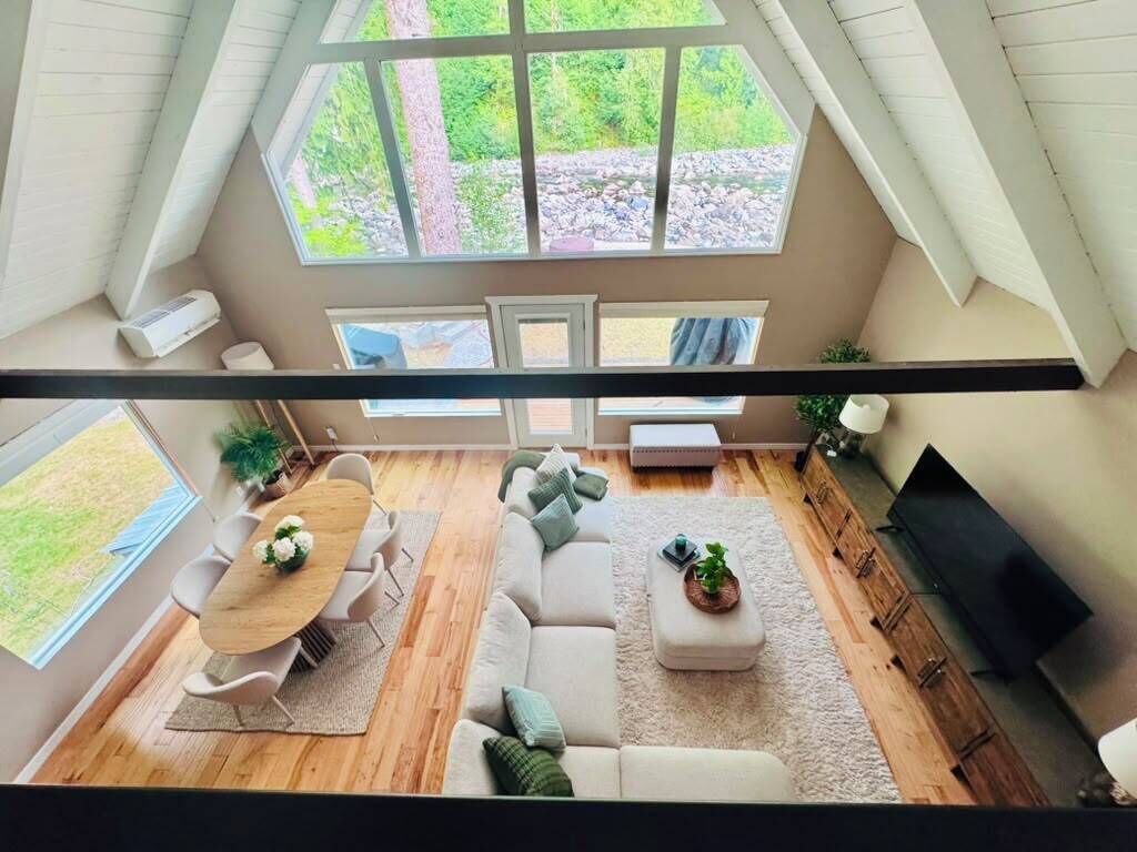 Ein moderner Loft-Wohnraum mit Essbereich, Sitzgelegenheiten und Fernseher.