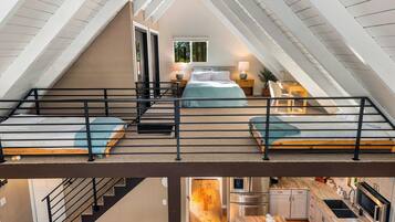 Ein Schlafzimmer mit Schlafgalerie, einer Treppe und einer Küchenzeile.