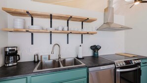 A modern kitchen with a stainless steel sink, a coffee maker, a built-in oven, and a dishwasher. - Central Carousel (Bend)