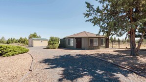 A two-story building with a gravel driveway and a small garden area. - Central Carousel (Bend)
