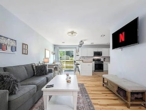 Una sala de estar moderna con un sofá, una mesa de centro y un televisor montado en la pared.