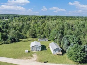 A rural property with a barn, a small house, and a trailer.