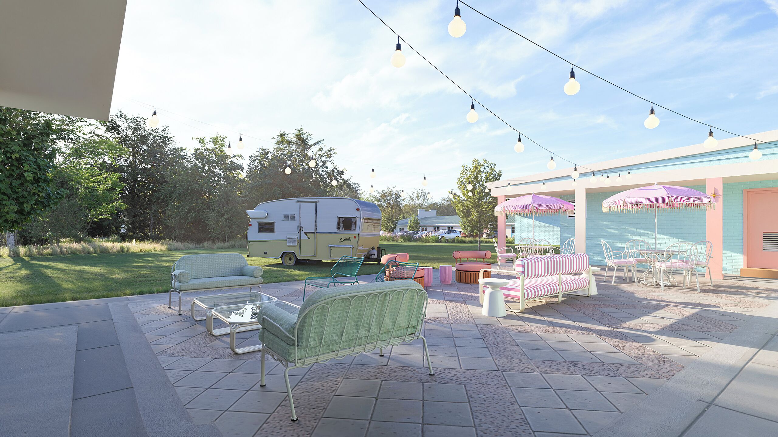 An outdoor patio area with seating, a caravan, and string lights.
