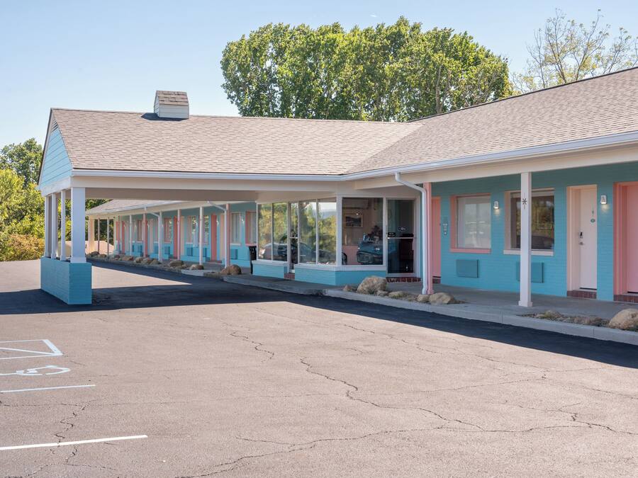 Un motel con estacionamiento techado y habitaciones individuales con acceso directo.