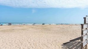 A sandy beach with a wooden fence and a signpost. - Direct Beachfront 3BR - 3 Pools & 3 Jacuzzis (South Padre Island)