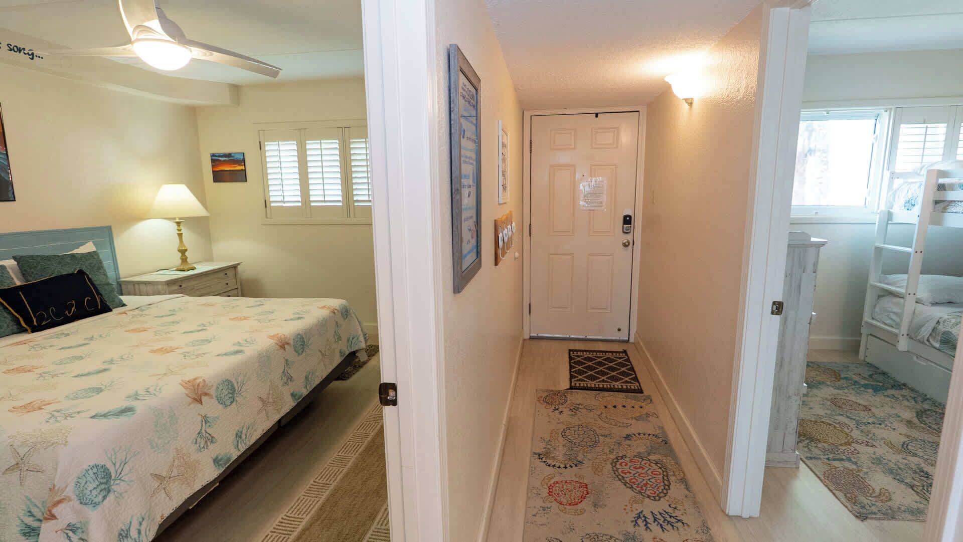 A bedroom with a bed, a nightstand, a lamp, a ceiling fan, and a window with blinds.