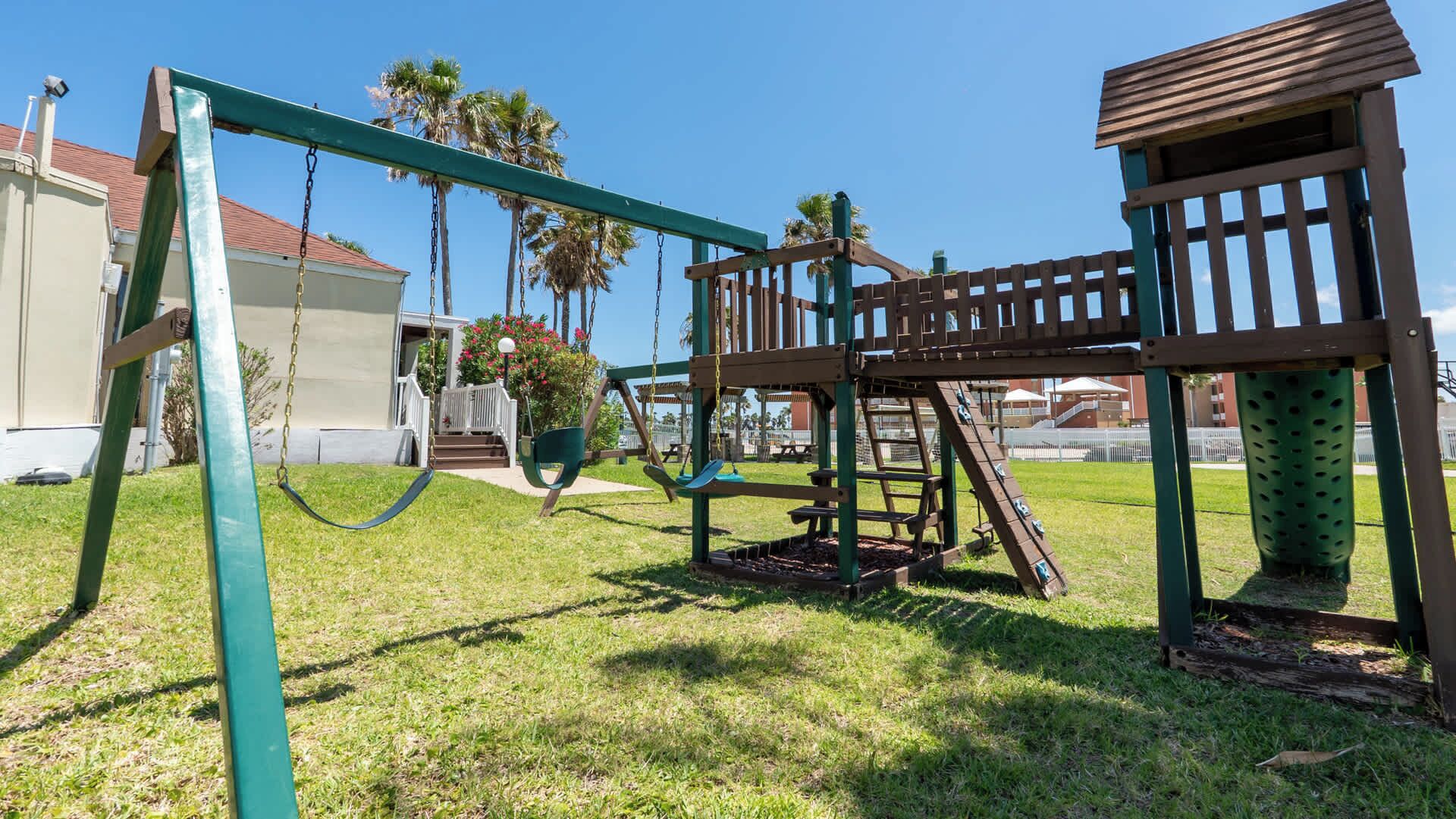 Un parque infantil con columpios y una estructura para escalar.