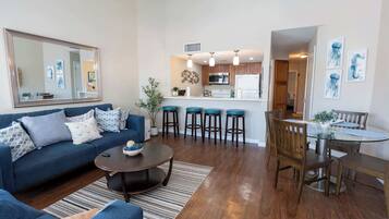 Una sala de estar moderna con un sofá, una mesa de centro y un comedor con una mesa y sillas.