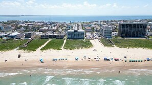 Eine Küstenstadt mit Strand, Gebäuden und freiem Blick auf den Ozean.