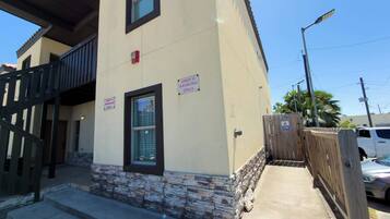 A building with a stone base, two windows, and signs indicating 'Unit 2 Parking Only' and 'Unit 4 Parking Only.'