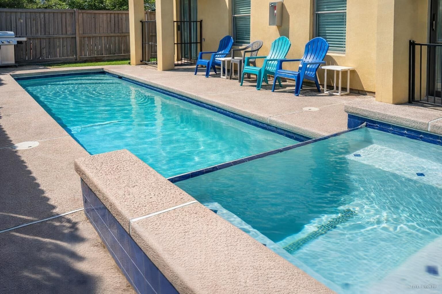 Piscina rectangular con dos zonas diferenciadas, rodeada por una solera de concreto.