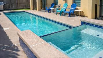 Piscina rectangular con dos zonas diferenciadas, rodeada por una solera de concreto.