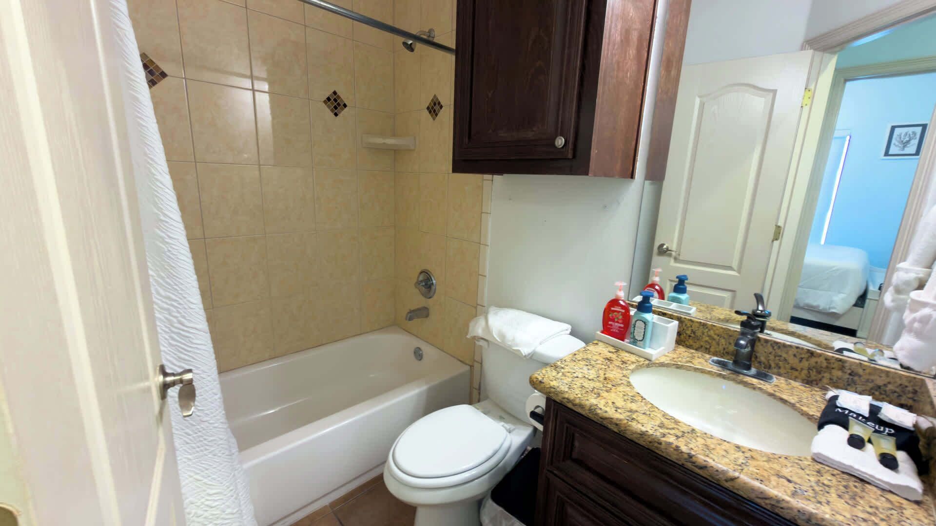 A bathroom with a bathtub, toilet, and sink.