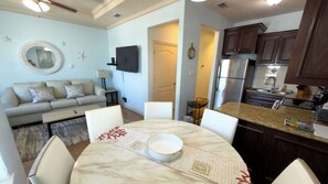 A modern kitchen with dark wood cabinets, a stainless steel refrigerator, and a granite countertop. - Near Beach Retreat - Ground Floor - Pool - Walk to All (South Padre Island)