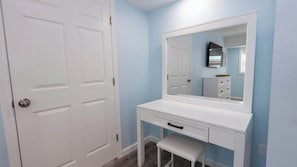 Un bany amb un lavabo blanc, un mirall gran i una porta.
