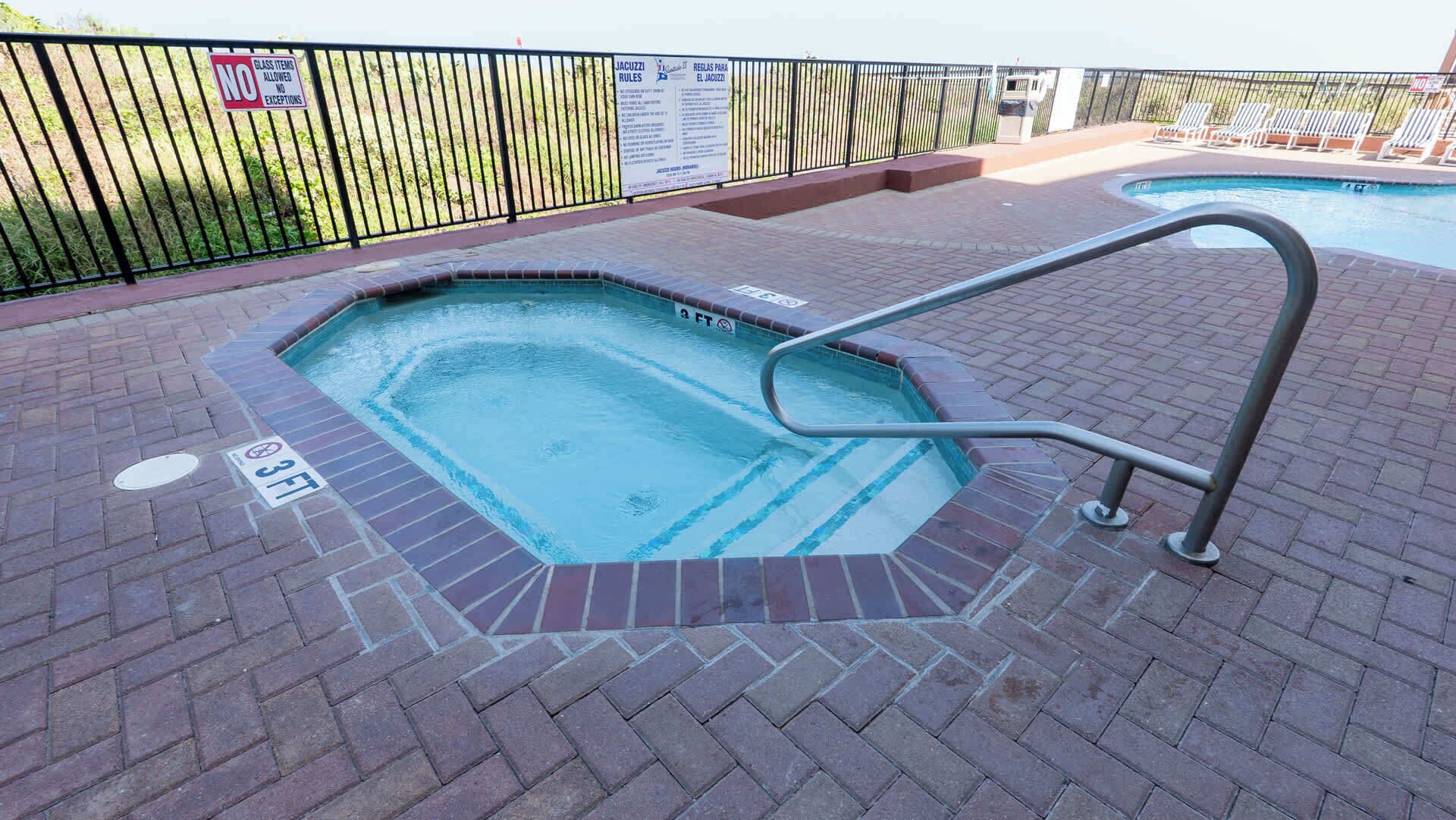 A hot tub with a metal ladder, surrounded by a brick patio.