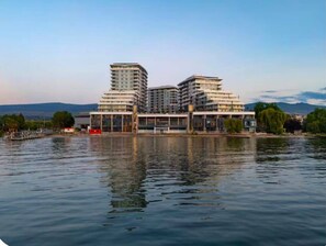 A waterfront hotel with multiple buildings, a dock, and a calm body of water. - Luxury Beachfront | 2 Bed | Pool & Hot Tub | Gym (Kelowna)