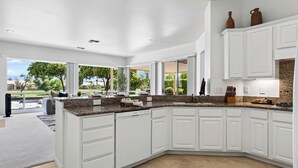 A modern kitchen with white cabinetry, granite countertops, and a large island. - Palm & Par by Avantstay Golf Views + Patio BBQ Mins to Indian Wells (Palm Desert)