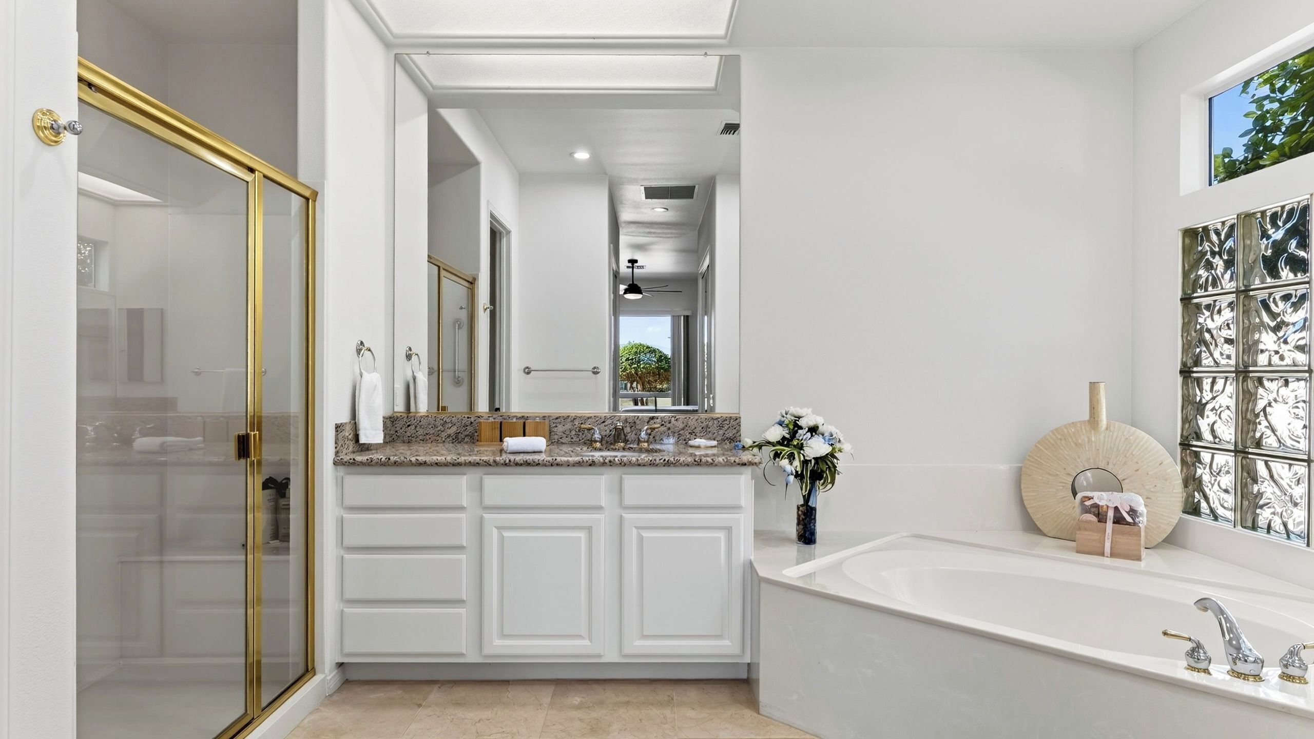 A modern bathroom with a walk-in shower, a freestanding bathtub, and a vanity with a granite countertop.